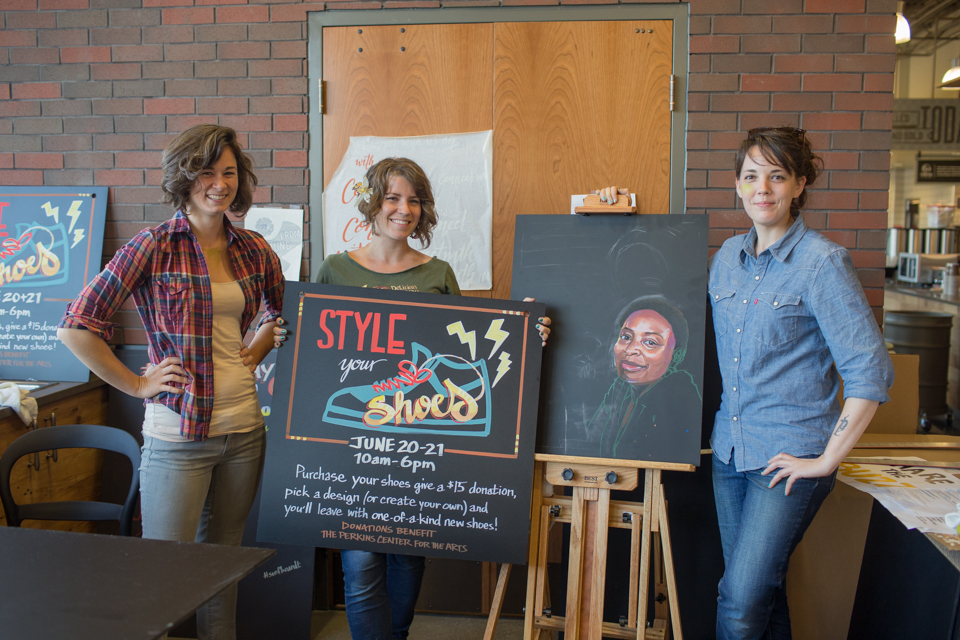 From left: graphic artists Kelly Franklin, Monica Kelly, and Carol Paist display some of the hand-lettered signs they've created in the market's in-house art department. Credit: Tricia Burrough/Lilac Blossom Photography.